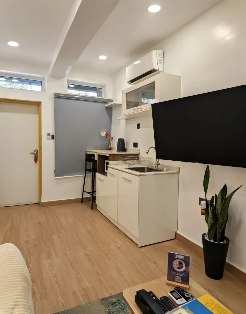 Ruby Studio Kitchenette view with TV onsite.webp